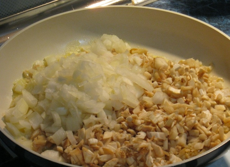 1. Этап. Грибы, фаршированные фаршем: Затем выкладываем на сковороду нарезанные грибные ножки и лук и жарим до тех пор, пока из грибов не выпариться лишняя жидкость.