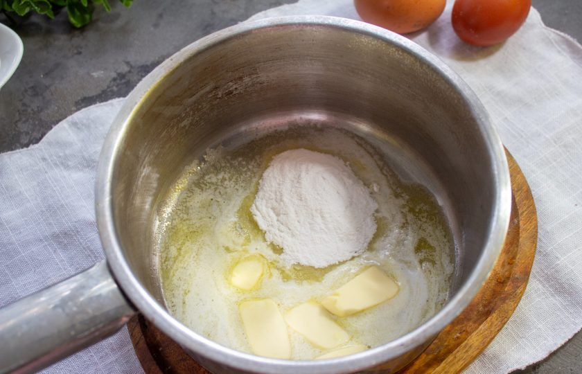 1. Этап. Суфле из яиц: В сотейнике растопите сливочное масло, добавьте муку. Перемешайте.