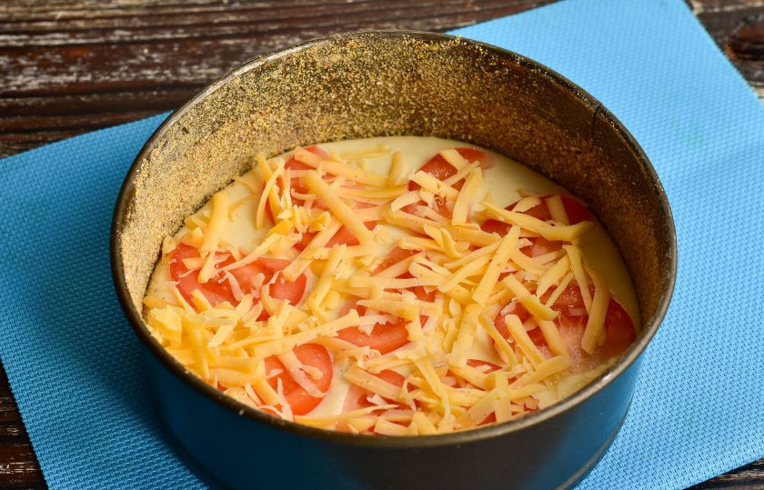 1. Этап. Заливной пирог с помидорами и сыром: Сверху на помидор выложите тертый твердый сыр.