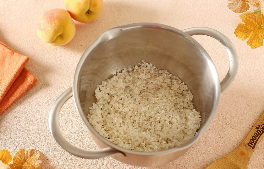 1. Этап. Рисовая каша с персиками: Рис промойте и переложите в кастрюлю.