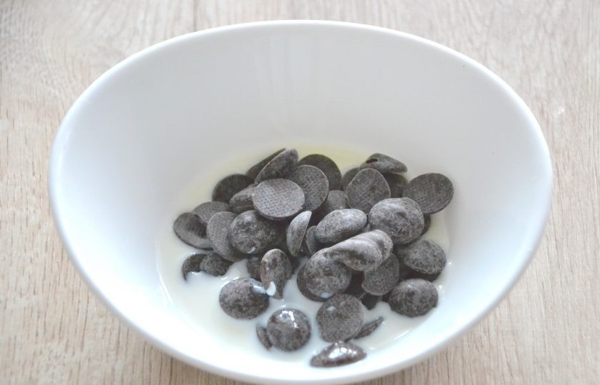 1. Этап. Крем Пломбир для эклеров: Для приготовления шоколадной глазури смешайте 60 грамм шоколада с двумя столовыми ложками молока, растопите в микроволновой печи короткими импульсами по 15 секунд.