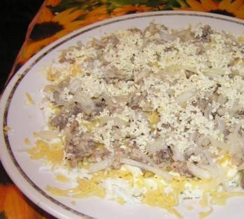 1. Этап. Слоеный салат с рыбными консервами: 3. Сардины отцеживаем от масла, разминаем вилкой и выкладываем поверх сырного слоя. Лук режем как можно более тонкими полукольцами и выкладываем поверх рыбы. Я еще присыпала тертым на терке замороженным сливочным маслом.