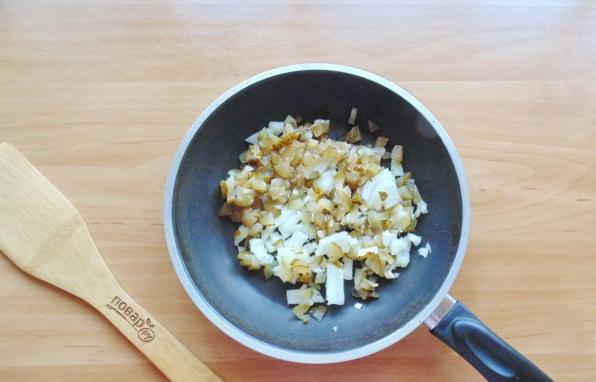 1. Этап. Белая солянка: Соленый или маринованный огурец мелко нарежьте и выложите в сковороду. Репчатый лук очистите, помойте и мелко нарежьте. Добавьте к огурцу.