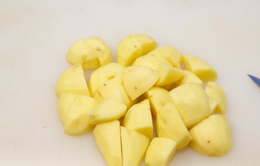 1. Этап. Карри со свининой: Первым делом нужно отправить картофель. Очистите его и нарежьте некрупными дольками. Затем отварите его в подсоленной воде до готовности. Это займёт около 15-20 минут.
