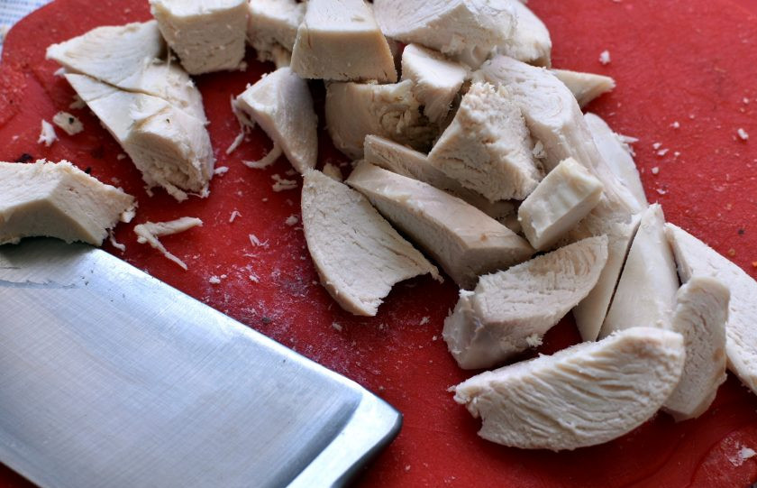 1. Этап. Хрустящий салат с курицей и овощами: Запеченную куриную грудку нарежьте не тонкими ломтиками и добавьте в миску.