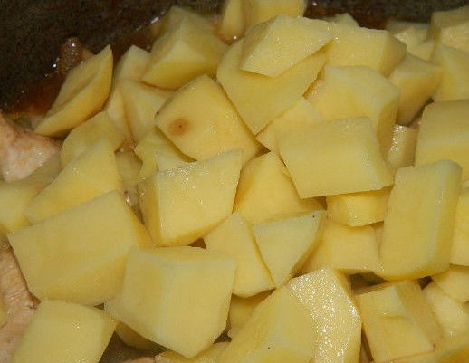 1. Этап. Гуляш куриный: 5. Очистите картошку, вымойте её и нарежьте брусочками. Положите в казанок. Налейте еще полтора стакана воды и тушите минут 10.