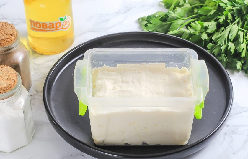 1. Этап. Домашняя брынза из творога: Смажьте пищевой контейнер или небольшую пиалу сливочным или растительным маслом и утрамбуйте в нее творожную массу. Закройте крышкой и поместите в холодильник минимум на 4-6 часов, а лучше — на ночь.