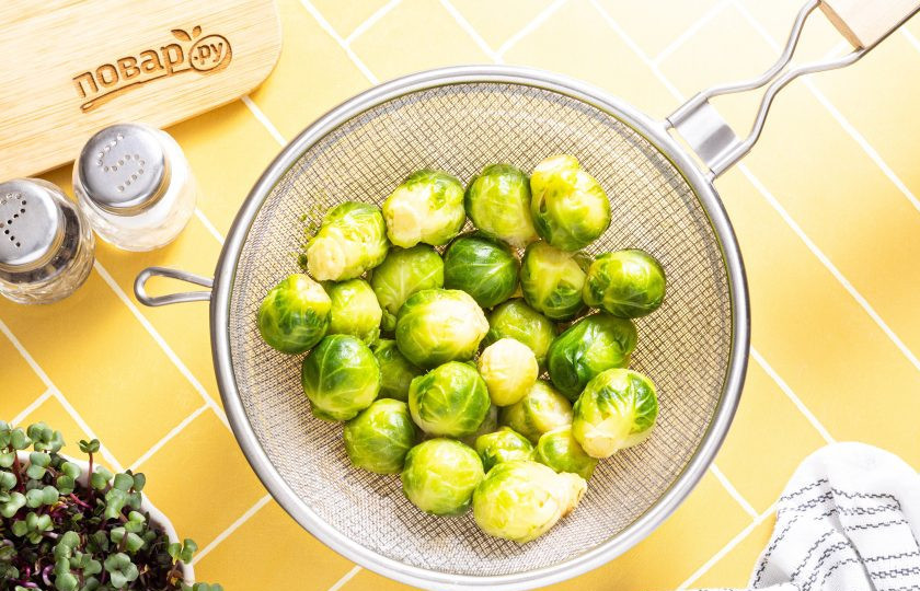 1. Этап. Брюссельская капуста по-брюссельски: После слейте воду, откиньте брюссельскую капусту на сито и дайте стечь жидкости.