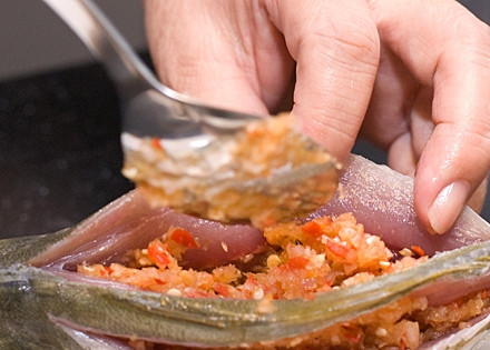 1. Этап. Жареная рыба с чили-пастой: 4. Начините рыбу подготовленной овощной начинкой и смажьте ее растительным маслом.