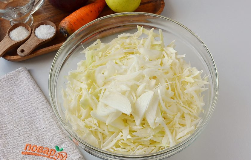 1. Этап. Салат Кремлевский: Нашинкуйте мелко капусту, лук порежьте полукольцами. Сложите в большую миску или кастрюлю.