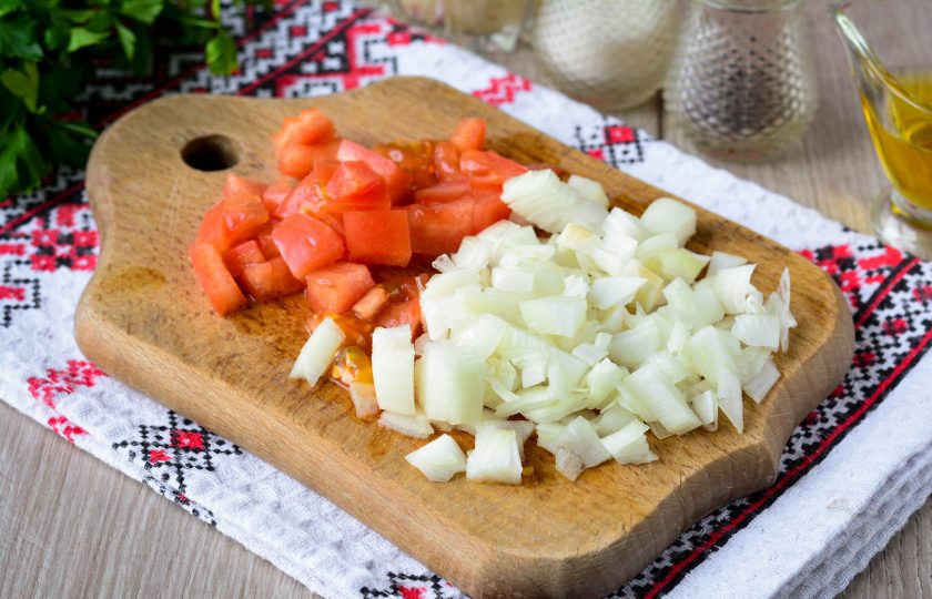 1. Этап. Рассыпчатый рис в сковороде: Нарежьте кубиками репчатый лук и помидоры.