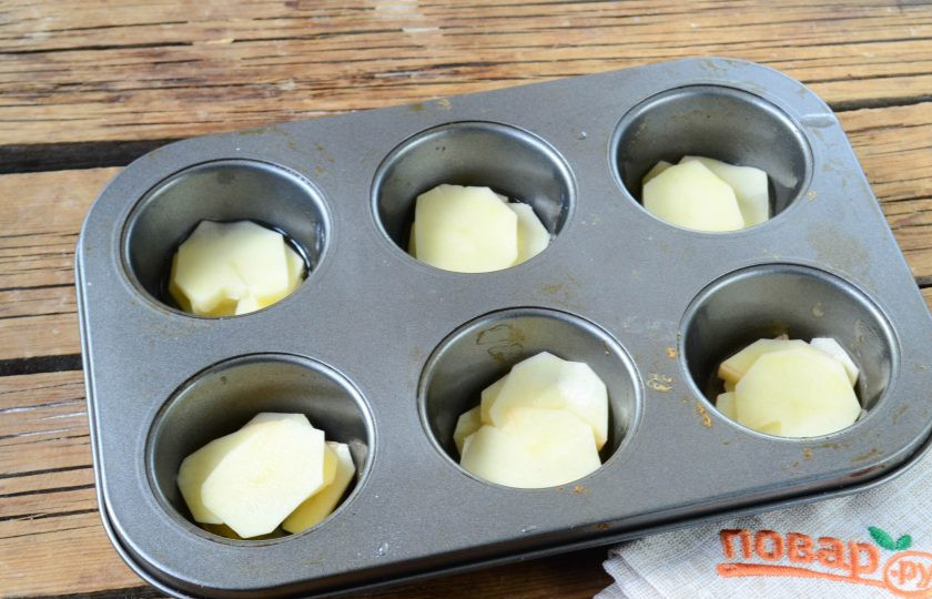 1. Этап. Гратен из картофеля в стиле маффинов: Картофель порежьте тонкими слайсами. В формы для маффинов положите картофельные слайсы примерно до половины формы.