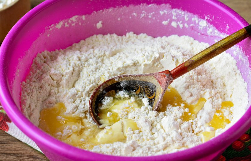 1. Этап. Торт Наполеон советский: Просейте муку, разрыхлитель для теста в миску и влейте жидкую основу из яйца, сахара, соли, молока и сливочного масла.