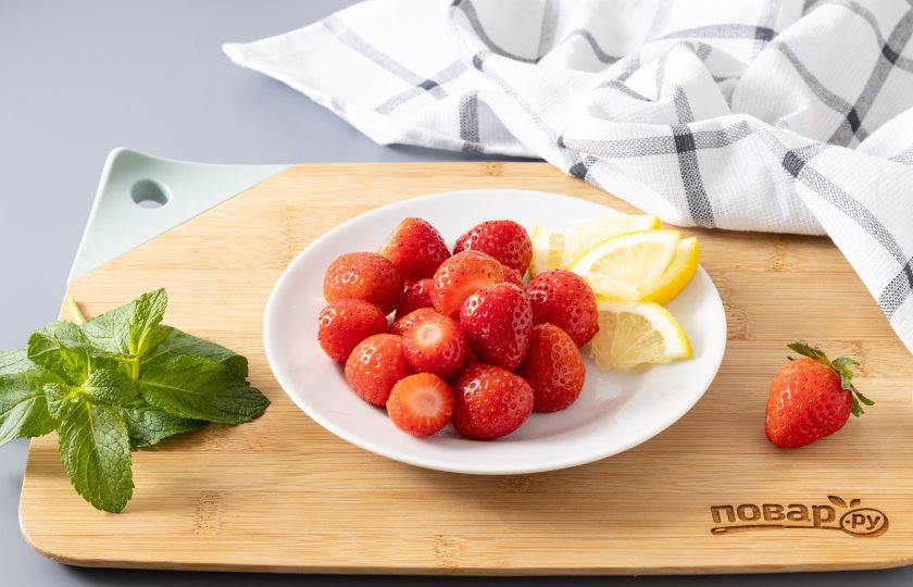 1. Этап. Компот из клубники, лимона и мяты на зиму: Клубнику помойте, обсушите и отрежьте хвостики. У лимона отрежьте пару кружочков, а мяту промойте, обсушите и при необходимости оторвите вялые испорченные листики.