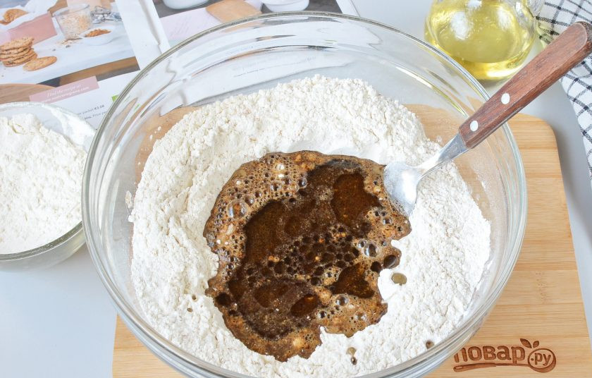 1. Этап. Рецепт хлеба с солодом: Сделайте углубление в муке, влейте теплый солод с дрожжами, растительное масло.