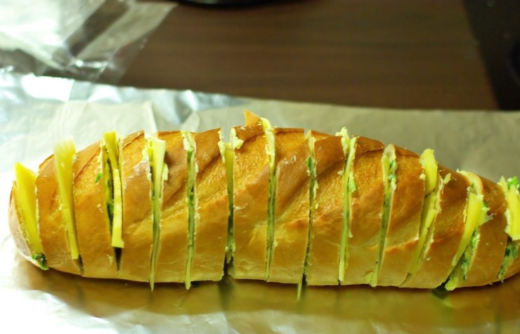 1. Этап. Сырный хлеб: Батон кладем на фольгу и в каждый надрез вставляем по кусочку плавленного сырка.