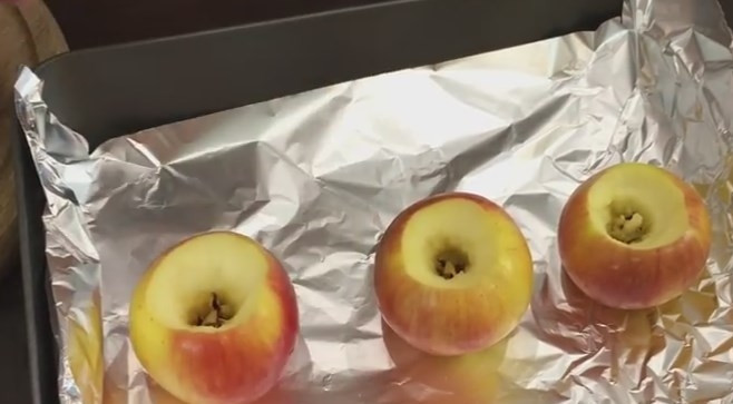 1. Этап. Запеченные яблоки с орехами и изюмом: 2. Ножом аккуратно вырежьте срединку, стараясь не проткнуть яблоки насквозь, иначе будет вытекать сок во время запекания. Противень застелите фольгой и выложите туда яблоки.