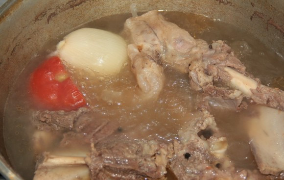 1. Этап. Сорпа по-казахски: Добавляем в кастрюлю целиком лук и помидор.