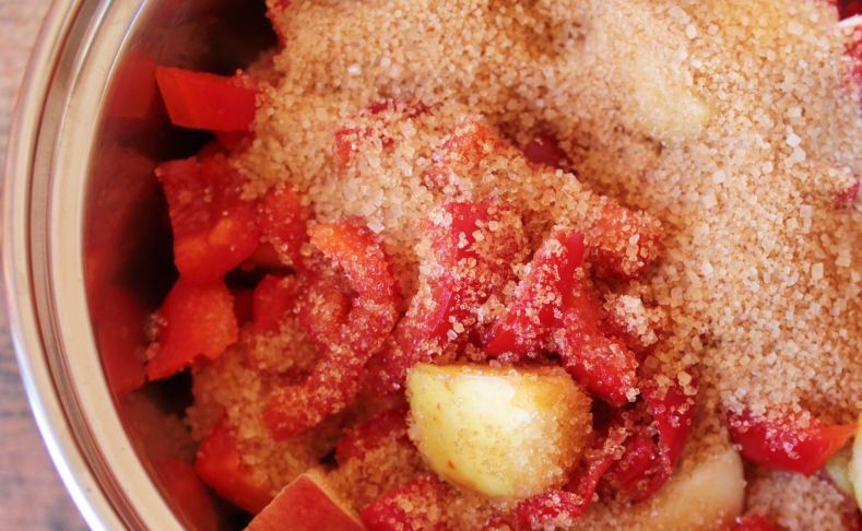 1. Этап. Заготовка из яблок на зиму: Нарезанные яблоки переложите в глубокую кастрюлю или сотейник вместе с перцем и засыпьте сахаром. Оставьте фрукты в таком состоянии на ночь, чтобы они пустили сок.