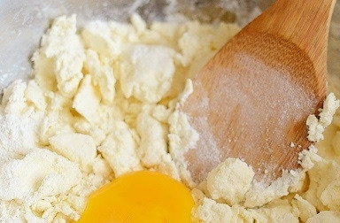 1. Этап. Именинный пирог: Сливочное масло достаньте из холодильника. Дайте ему постоять, чтобы оно размягчилось. Затем просейте в миску, смешайте с солью, разрыхлителем, сахаром, разотрите все в крошку со сливочным маслом. После вбейте сырое яйцо.