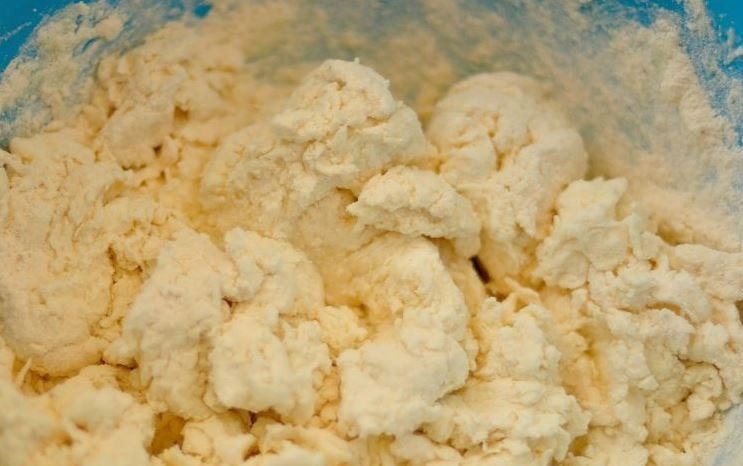 1. Этап. Сырники без жарки: Просейте муку через сито несколько раз, затем соедините ее с разрыхлителем и содой, чтобы сырники получились пышными. Добавьте сухие ингредиенты к творожной массе и замесите тесто.