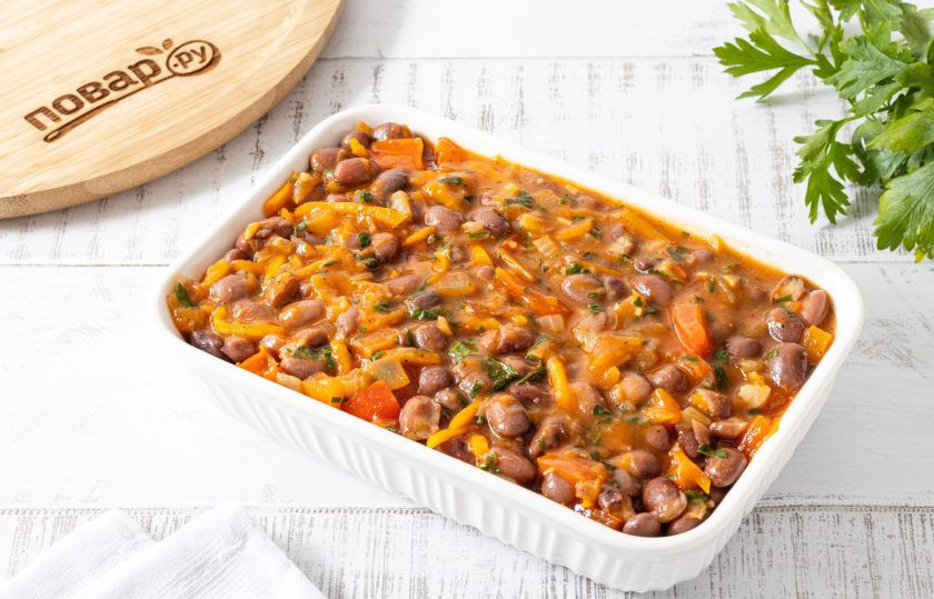 1. Этап. Балканская овощная закуска Тавче гравче: Фасоль выложите в форму для выпечки. Добавьте овощную подливку. Перемешайте и выпекайте примерно 30-40 минут в разогретой до 190 градусов духовке до румяной корочки.