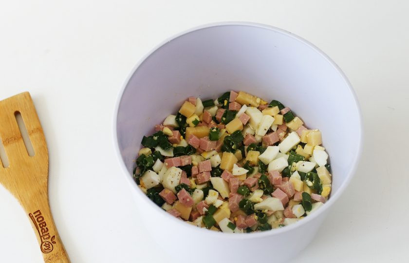 1. Этап. Пирог на майонезе в мультиварке: Для начинки нарежьте кубиками вареные яйца, сыр и колбасу. Добавьте зеленый лук, соль и черный молотый перец по вкусу.