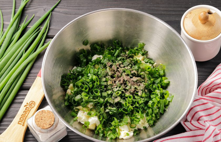 1. Этап. Дрожжевой пирог с яйцом в духовке: Сваренные вкрутую яйца остудите, а затем очистите и нарежьте кубиком. Добавьте мелко рубленный зелёный лук, соль и молотый перец по вкусу.