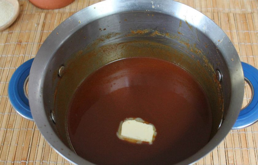 1. Этап. Карамельный торт без выпечки: Сливочное масло и соль добавляем, когда карамель немного остынет. Затем, все перемешиваем. Карамель используем трижды. Часть откладываем для поливки готового торта. Вторая часть нужна для пропитки нижнего слоя из хлопьев, изюма и семечек. Третья, основная часть, нужна для приготовления творожного слоя (третья часть остается в кастрюле).