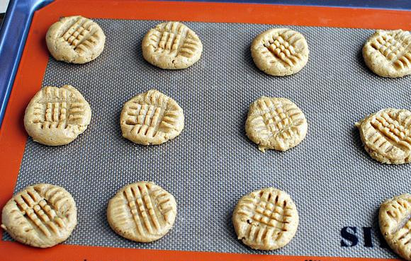 1. Этап. Печенье с арахисовым маслом и медом: 5. Придавить шарики вилкой, держа ее сначала в одном направлении, а затем в перпендикулярном, чтобы на печенье получилась решетка. Выпекать печенье в духовке, пока оно не начнет темнеть по краям, около 9-10 минут.