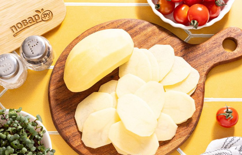 1. Этап. Чипсы из картошки в аэрогриле: Картофель помойте, очистите от кожуры. Натрите картофель на тонкие слайсы с помощью специальной терки или овощечистки.