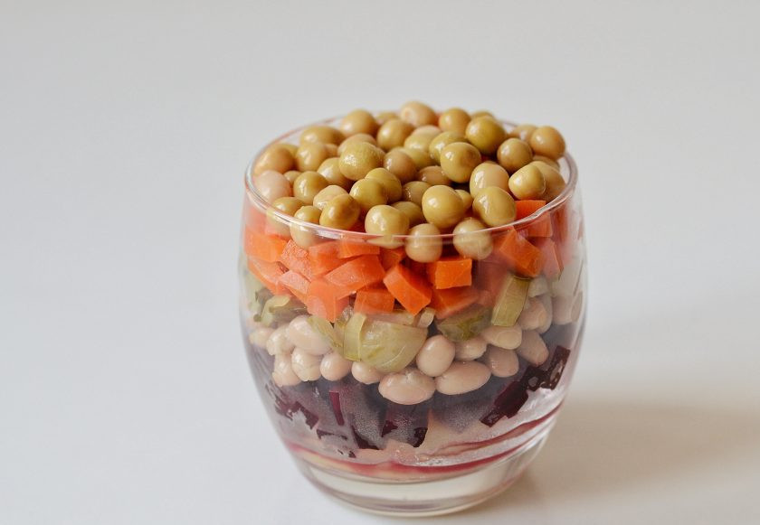 1. Этап. Слоеный винегрет: Выложите салат в следующем порядке: картошка, свекла, фасоль, огурцы, морковь. Сверху украсьте горошком. Каждый слой поливайте заправкой.