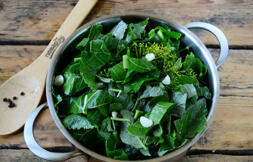 1. Этап. Малосольные огурцы за сутки: Накройте их оставшейся смесью зелени, положите чеснок и перец. Кастрюля должна получиться почти полной.