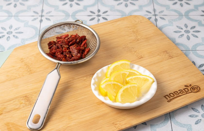 1. Этап. Чай с ягодами годжи: Лимон нарежьте на небольшие ломтики. Ягоды годжи промойте в теплой воде и откиньте на сито, чтобы стекла лишняя жидкость.