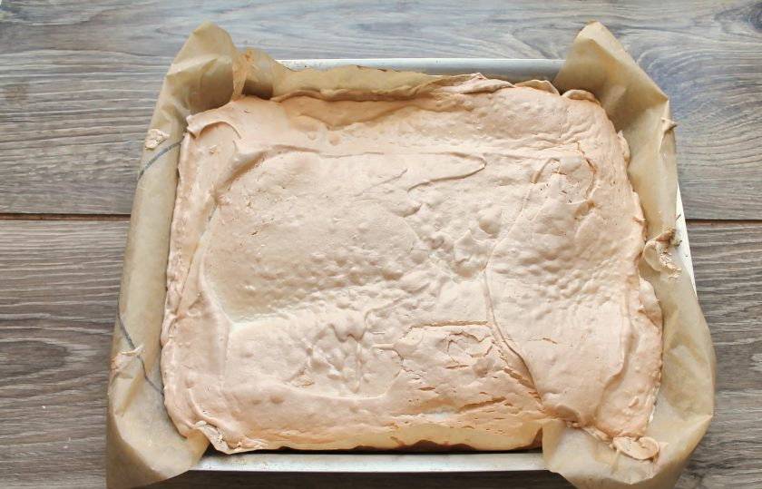 1. Этап. Меренговый рулет с клубникой: Поставьте противень в горячую духовку и выпекайте в течение 25 минут до румяной корочки при температуре 160 градусов. Достаньте противень и переверните меренговый слой на другой лист пергамента или силиконовый коврик. Дайте постоять 3-5 минут и снимите пергамент, дайте полностью остыть.