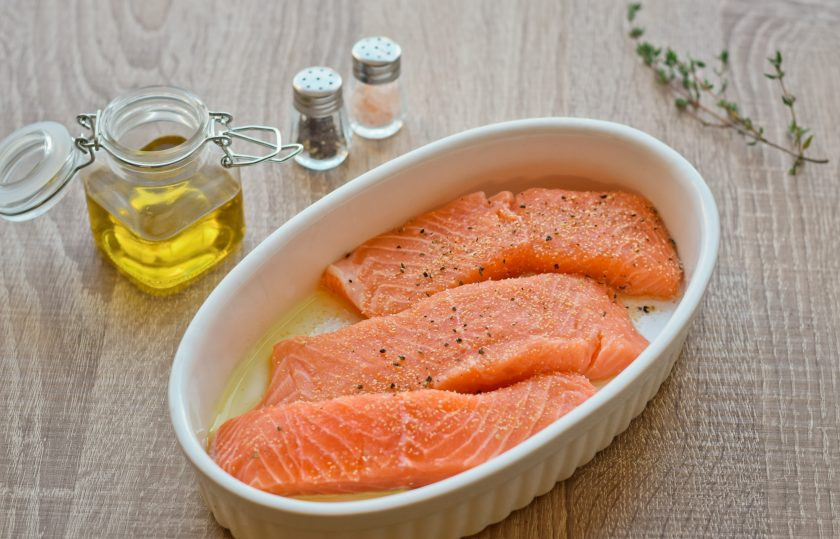 1. Этап. Семга в сливочном соусе запеченная в духовке: Форму для духовки смажьте оливковым маслом. Выложите в форму кусочки рыбы. Посолите и приправьте молотым перцем. По желанию можете добавить немного сухого чеснока.