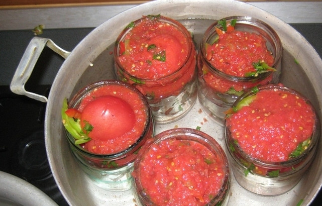 1. Этап. Солянка с помидорами: Банки поставьте в высокую кастрюлю, налив туда предварительно воды. Накройте кастрюлю крышкой и держите помидоры под ней 15-20 минут. Когда они осядут, а сок поднимется к горлышку, банки можно закручивать.