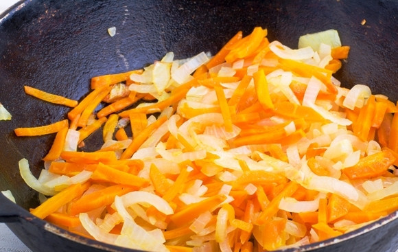 1. Этап. Кабачковая икра с морковкой: 5. Выложите на отдельную сковороду с небольшим количеством масла и обжарьте 5-7 минут, периодически помешивая. Добавьте немного чеснока по вкусу.