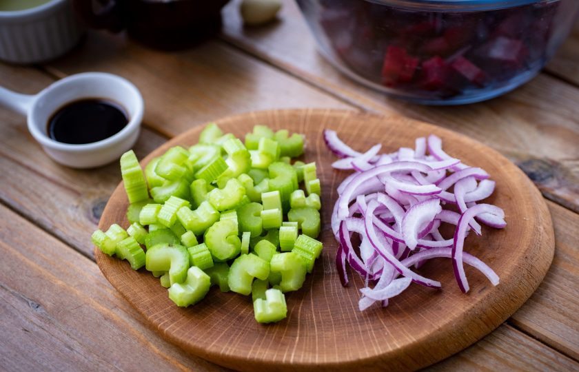 1. Этап. Салат сливочный сыр со свеклой: Стебли сельдерея промойте в проточной воде и нарежьте небольшими кусочками. Фиолетовый лук почистите и нарежьте тонкими полукольцами.