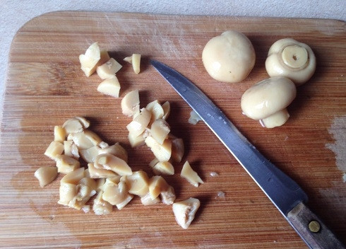 1. Этап. Салат из кальмаров с грибами: Нарезаем кубиками маринованные грибы. У меня шампиньоны, но можно использовать любые другие.