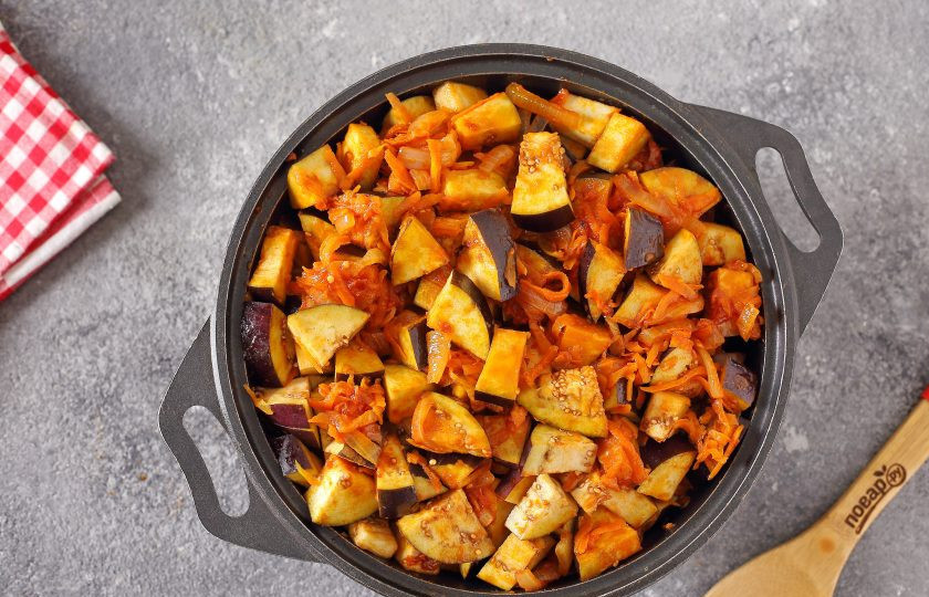 1. Этап. Икра из баклажанов на зиму Пальчики оближешь: Добавьте лук с томатной пастой и морковь. Влейте воду, перемешайте и тушите 1 час. Каждые 15 минут овощи перемешивайте.