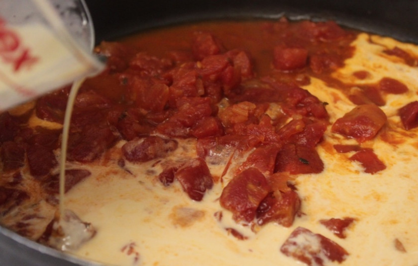 1. Этап. Паста с беконом и креветками: В сковороде, где жарился бекон, доводим до кипения сливки с консервированными помидорами.