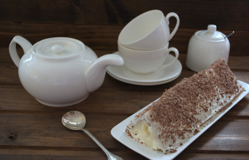 1. Этап. Домик из печенья: Натрите на терке шоколад. Посыпьте им крышу домика.