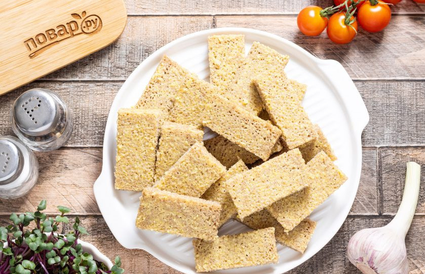 1. Этап. Гренки в аэрогриле: Затем ножом снимите чесночное пюре с ломтиков. Нарежьте хлеб брусочками одинаковой ширины.