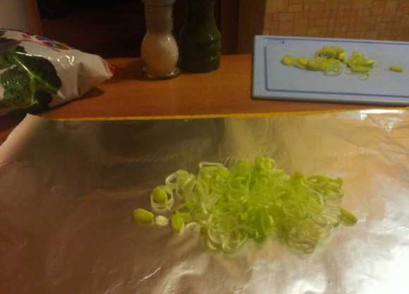 1. Этап. Брокколи в фольге в духовке: Нарежьте лук порей колечками и положите по центру фольги.