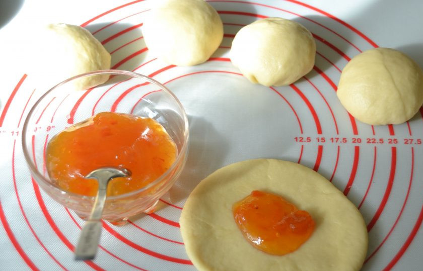 1. Этап. Булочки Бухтельн: Раскатайте шар в лепешку диаметром около 10 см. В центр лепешки выложите джем.