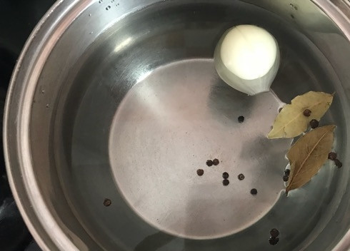 1. Этап. Яичный суп из Андалусии: 1. Поставьте на плиту кастрюлю на 1.5 литра воды и сварите бульон из луковицы, лаврового листа, черного перца и бульонного кубика.