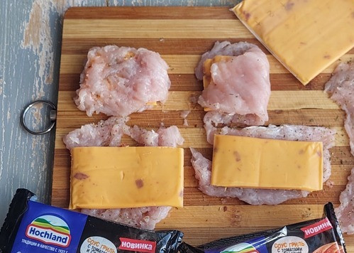 1. Этап. Запеченные овощи с курицей и сыром: Пластинки плавленого сыра разрезать пополам, разложить на курином филе, сложить пополам.