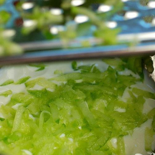 1. Этап. Райта салат: Налейте йогурт в миску и на грубой тёрке натрите огурец.