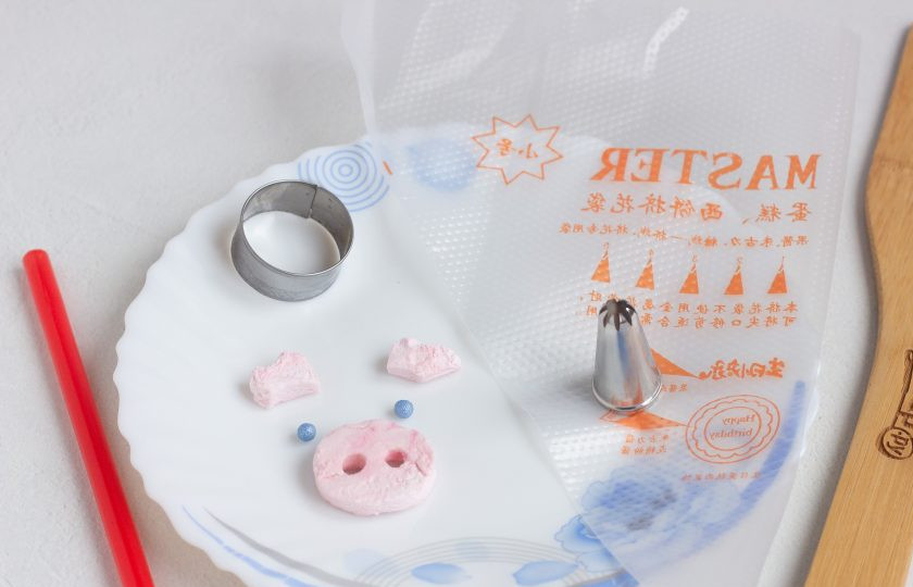 1. Этап. Лимонные кексики Розовые свинки: Пока остывают кексы можно подготовить вот такой декор для свинок из зефира. Зефир нарежьте острым ножом пластинами и вырезайте нужные элементы: пяточок и ушки. Для глаз я использовала кондитерские бусины, можно взять шоколадные капли. Ротик можно нарисовать пищевым фломастером или обойтись без него! Также подготовьте насадку и мешок для крема.